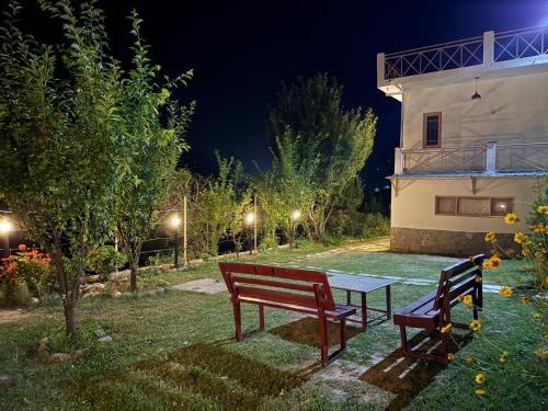 two benches and a table in a yard at night at Gound Floor Studio Appartment in Kulu
