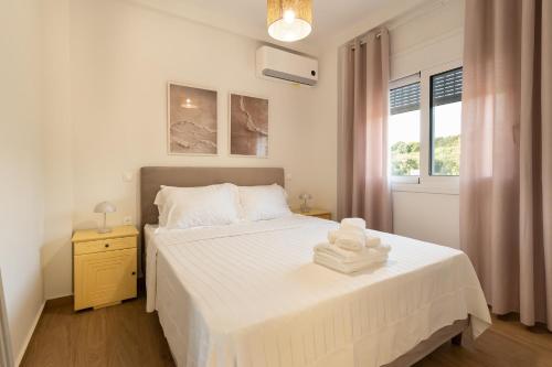 a bedroom with a white bed and a window at Casa Elaia in Pylos