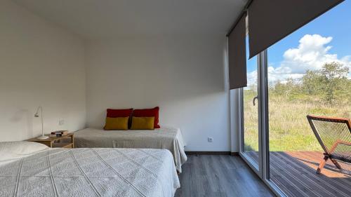 a bedroom with two beds and a sliding glass door at LAZY HIKERS by Nature Bliss in São Luis