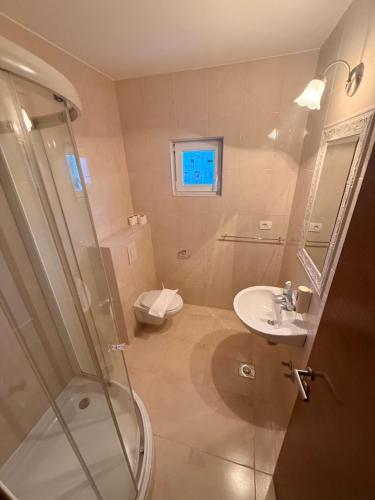 a bathroom with a shower and a sink and a toilet at Hotel BlueTwo Međugorje in Međugorje