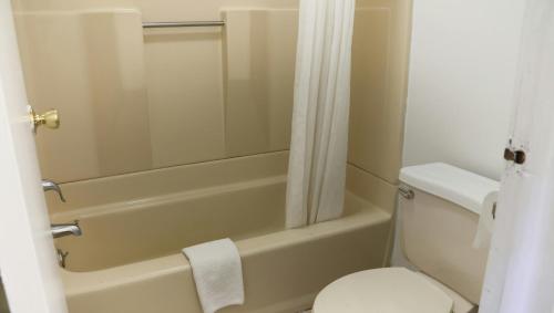 a bathroom with a tub and a toilet and a shower at Chippewa Motel Mount Pleasant in Mount Pleasant
