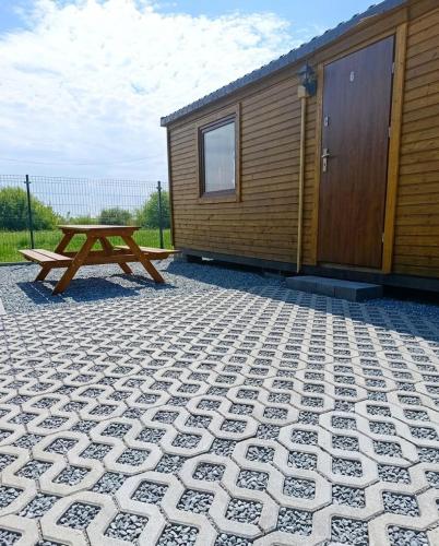 a picnic table in front of a cabin at Miodowe Domki in Władysławowo