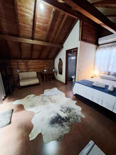 a bedroom with a bed and a rug on the floor at Pousada Capão Fôrro in São Roque de Minas