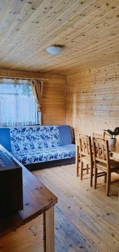 a living room with a couch and a table and chairs at Miodowe Domki in Władysławowo