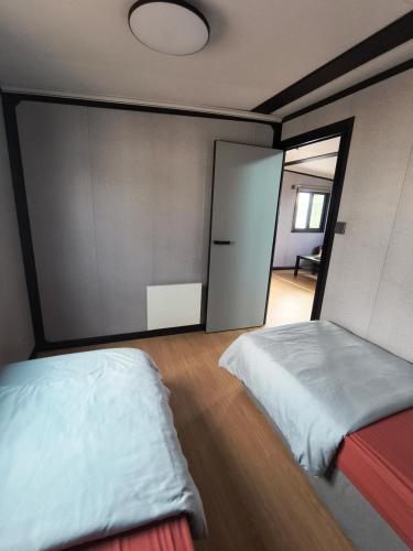 a bedroom with two beds and a large window at Studio MAT in Herly