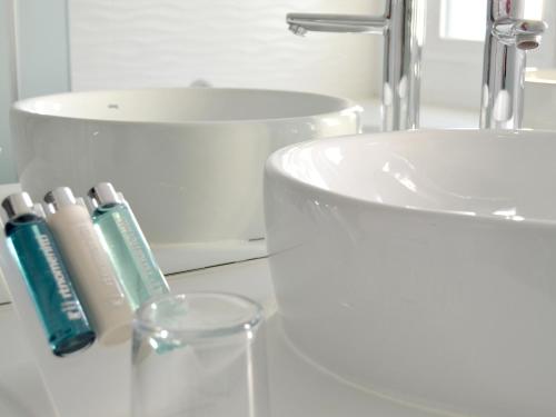 a bathroom with a sink and a toothbrush and a glass at UVE Alcobendas in Alcobendas