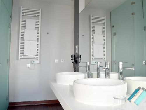 a bathroom with two sinks and two mirrors at UVE Alcobendas in Alcobendas