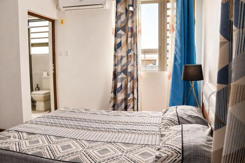 a small bedroom with a bed and a window at Zenith Apartment in Baie du Tombeau