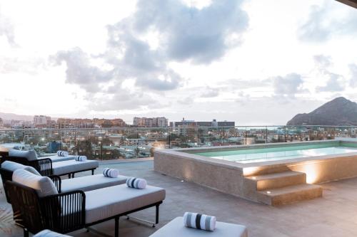 a rooftop patio with a pool and a view of the city at Double Suite Luxury Retreat 605 Tower in Cabo San Lucas