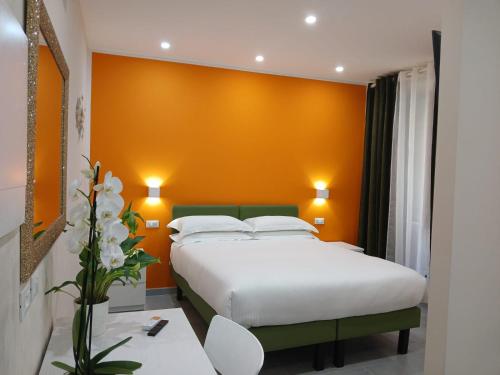 a bedroom with two beds and an orange wall at Affittacamere CINQUE TERRE LABI in La Spezia