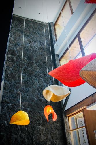Drei verschiedenfarbige Regenschirme hängen von der Decke in der Unterkunft Hotel Pucón Indómito in Pucón