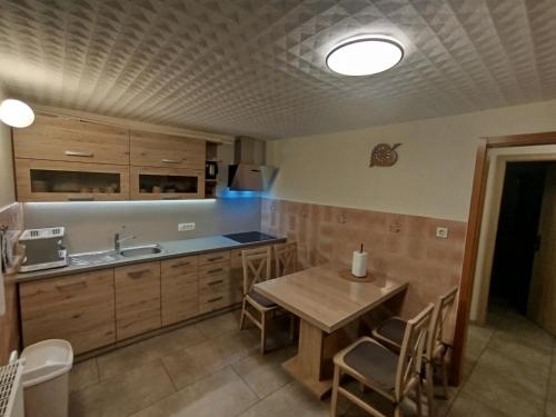 a kitchen with a wooden table and a sink at Apartma Silvester in Bovec