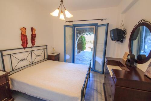 a bedroom with a bed and a dresser and a mirror at Anemos in Drios