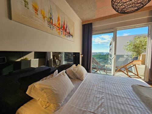 a bedroom with a bed with a large window at 74SUITE Sibenik - Self check in - Garage in Šibenik