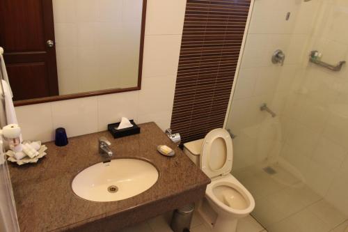 a bathroom with a sink and a toilet and a shower at juSTa Off MG Road in Bengaluru