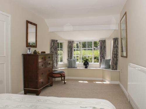 a bedroom with a window and a bed and a dresser at Upper Frogpool Cottage in Crediton