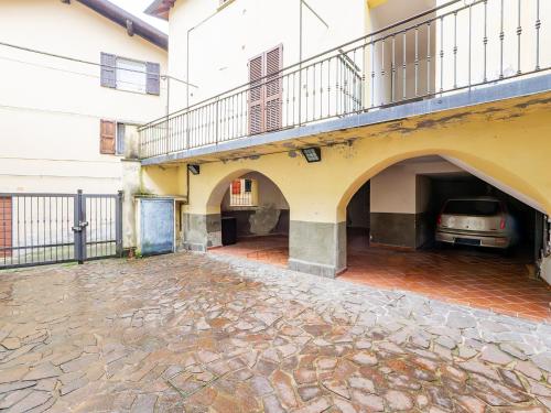 a building with a car parked under a balcony at White Nest - Lake Como & Ski Area in Ballabio