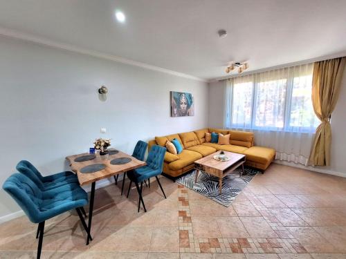 a living room with a couch and a table and chairs at Marina Forest in Sozopol