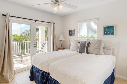 a bedroom with two beds and a balcony at KC28 Fantastic Fifth Street in Key Colony Beach