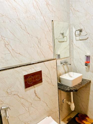a bathroom with a sink and a mirror at Shree Gurukripa Inn in Maheshwar