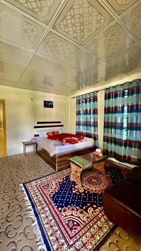 a bedroom with a bed and a large rug at Kepal Inn Hotel and Restaurant in Holshāl