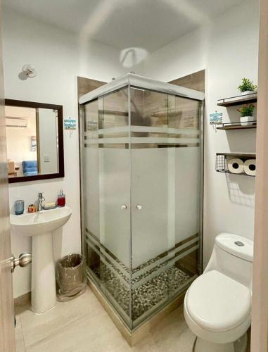 a bathroom with a shower and a toilet and a sink at Almarena Mazatlan Departamento Nautico in Mazatlán