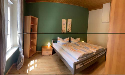 a bedroom with a bed and a green wall at Moselurlaub im Ferienweinhaus Koch in Neumagen-Dhron