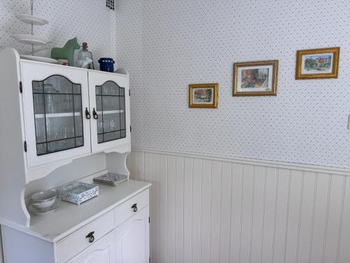 a bathroom with a white cabinet in a room at Sommerhaus Luisa in Vimmerby