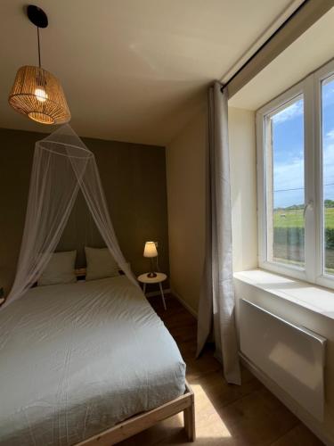 a bedroom with a canopy bed and a window at Cercy in Cercy-la-Tour