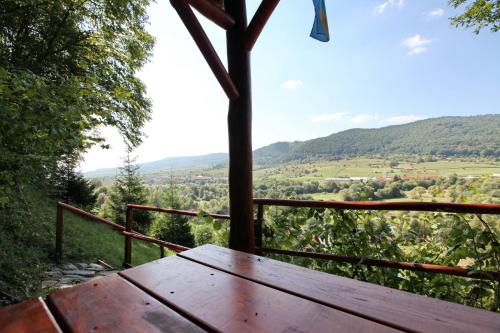 a wooden picnic table sitting on top of a hill at Pensiunea Hétvezér Panzió in Sub Cetate