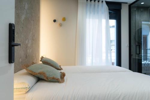a bedroom with a bed with two pillows on it at Ceramic Rooms Boutique Hostel in Villareal