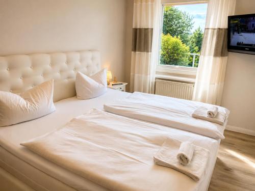 a bedroom with a white bed with towels on it at ZingstUrlauber in Zingst