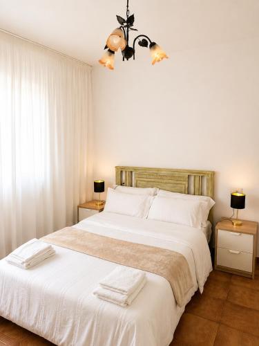 a bedroom with a large white bed with two lamps at Casa do Carballo in Nigrán