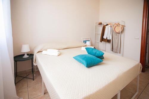 a bed with blue pillows on it in a room at Mediterranea Modica - Seaside Home in Marina di Modica