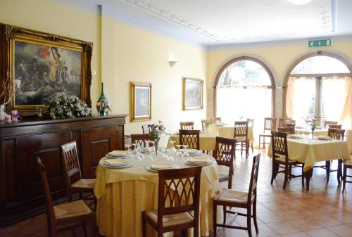 comedor con mesas y sillas y paredes amarillas en Hotel Funtana Noa en Villanovaforru