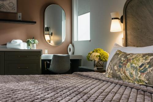 a bedroom with a bed and a vanity and a mirror at The Star on Spring in Springdale