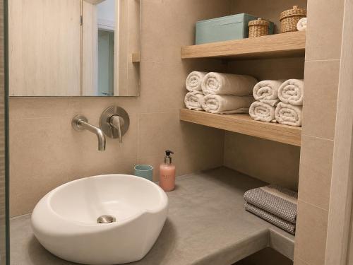 a bathroom with a white sink and towels at Selena Villa in Kamari