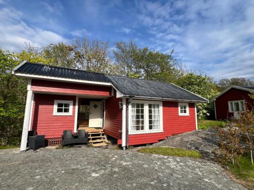 a red tiny house with a porch at Solheim in Ormelet