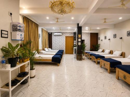 a hospital room with beds and plants and a chandelier at Rahat Dormitory in Jāmb