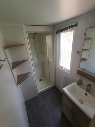 a bathroom with a shower and a sink and a mirror at Mobil'home Valras in Valras-Plage