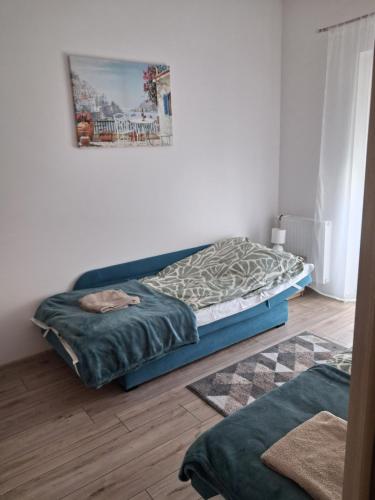 a bedroom with a bed and a painting on the wall at Apartament Perła Bałtyku in Grzybowo