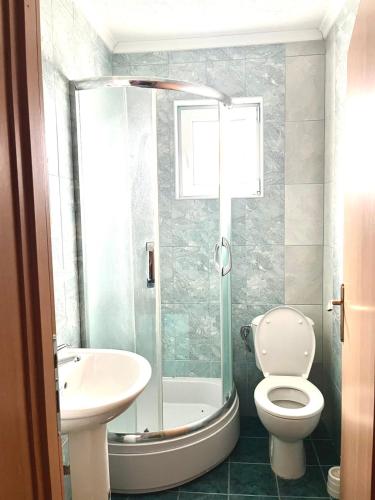a bathroom with a toilet and a sink and a shower at Apartments Vlavcheski in Peštani