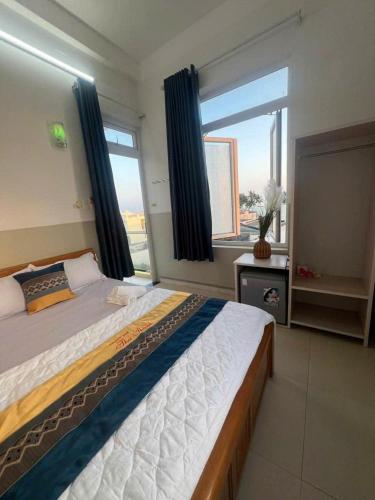 a bedroom with a large bed and a large window at Khách Sạn Thu Thành in Ly Son