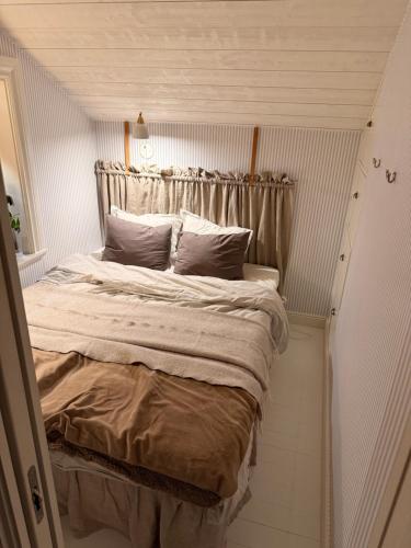 a bedroom with a large bed in a small room at Båtmansstugan i Gamla Stan in Kalmar