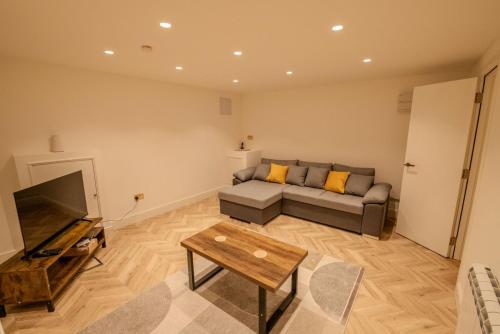 a living room with a couch and a tv at Rye Hideaway with Hot Tub - Rye in Rye