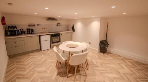 a kitchen with a white table and white chairs at Rye Hideaway with Hot Tub - Rye in Rye