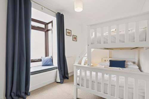 a white bedroom with a bunk bed and a window at 2 Bed in Swanage oc-wy547 in Swanage
