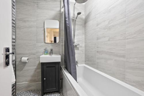 a bathroom with a tub and a sink and a shower at 2 Bed in Swanage oc-wy547 in Swanage