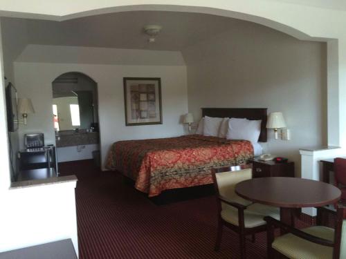 a hotel room with a bed and a table at Executive Inn Schulenburg in Schulenburg