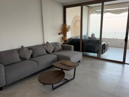 a living room with a couch and a table at Alamine plage in Fnidek